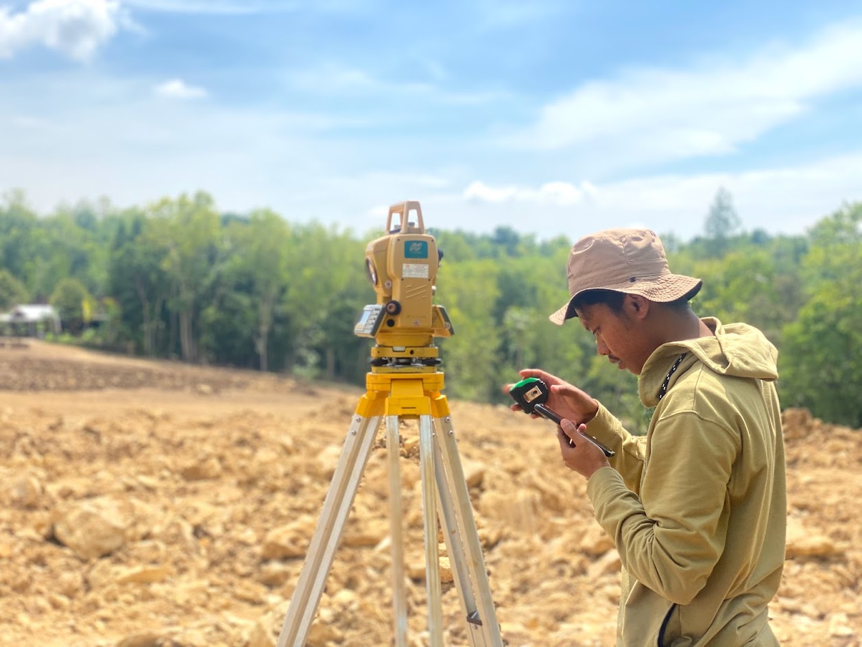 Pengukuran Topografi Surveyor melakukan pengukuran topografi menggunakan Total Station di lapangan